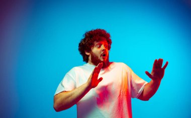 Beyaz adam portresi mavi stüdyo arka planında neon ışıkta izole edilmiş.