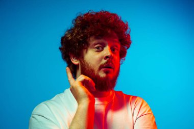 Beyaz adam portresi mavi stüdyo arka planında neon ışıkta izole edilmiş.