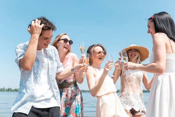 Fiesta estacional en el resort de playa. Grupo de amigos celebrando, descansando, divirtiéndose en la playa en el soleado día de verano —  Fotos de Stock