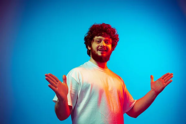 Retrato de hombre caucásico aislado sobre fondo de estudio azul en luz de neón —  Fotos de Stock