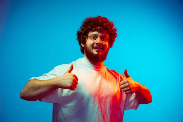 Retrato de hombre caucásico aislado sobre fondo de estudio azul en luz de neón —  Fotos de Stock