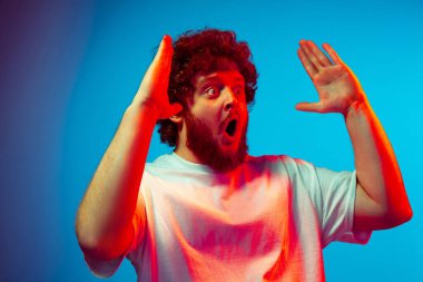 Beyaz adam portresi mavi stüdyo arka planında neon ışıkta izole edilmiş.