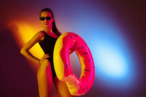 Menina sedutora bonita em maiô na moda na discoteca bicolor neon studio fundo em luz de néon. Verão, resort, moda e conceito de fim de semana — Fotografia de Stock