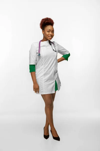 Beautiful african-american doctor or nurse smiling isolated over white studio background