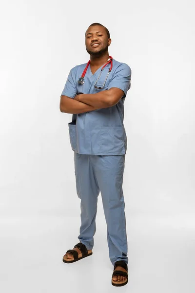 Hermoso médico afroamericano sonriendo aislado sobre fondo de estudio blanco — Foto de Stock