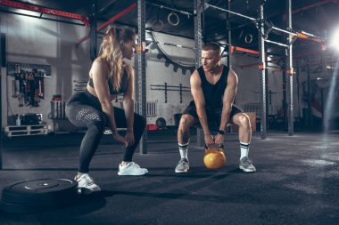 Güzel, genç, sportif çift eğitimi, spor salonunda birlikte antrenman.