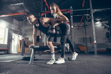 Güzel, genç, sportif çift eğitimi, spor salonunda birlikte antrenman.