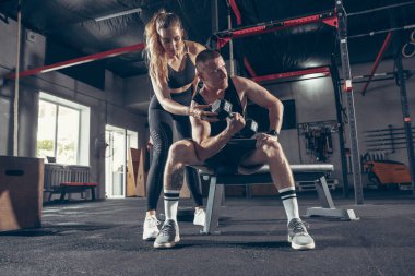 Güzel, genç, sportif çift eğitimi, spor salonunda birlikte antrenman.