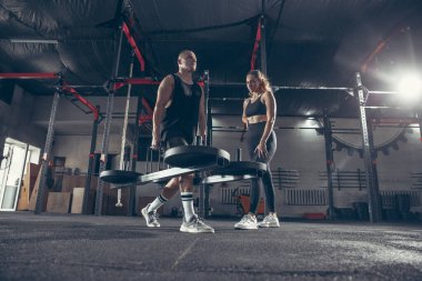 Güzel, genç, sportif çift eğitimi, spor salonunda birlikte antrenman.