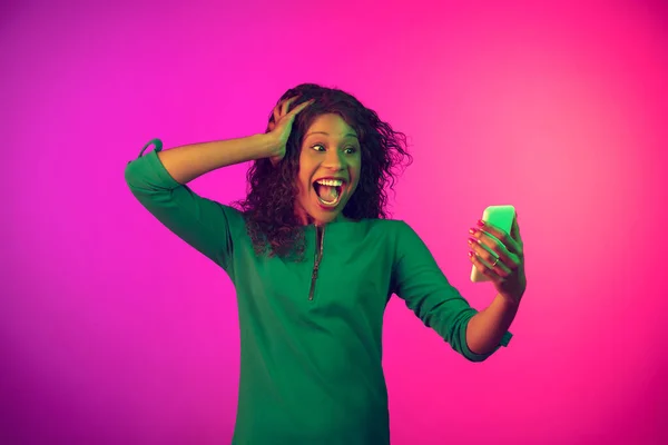 Portrait de jeune femme afro-américaine isolé sur fond rose dégradé au néon — Photo