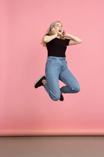 Portrait of young caucasian woman with bright emotions on coral pink studio background — Stock Photo, Image