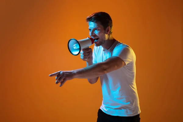 Caucasian beautiful young mans portrait on gradient orange studio background, emotional and expressive. Copyspace for ad. — Stock Photo, Image