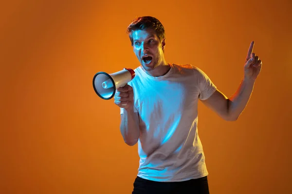 Caucasian beautiful young mans portrait on gradient orange studio background, emotional and expressive. Copyspace for ad. — Stock Photo, Image