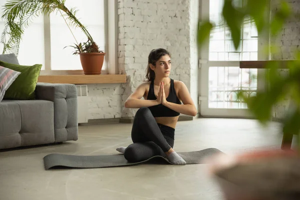 Sportieve jonge moslim vrouw die online yoga lessen neemt en thuis oefent — Stockfoto