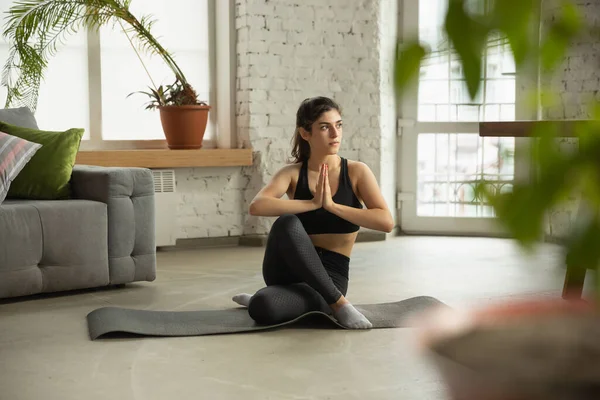 Deportiva joven musulmana que toma clases de yoga en línea y practica en casa — Foto de Stock