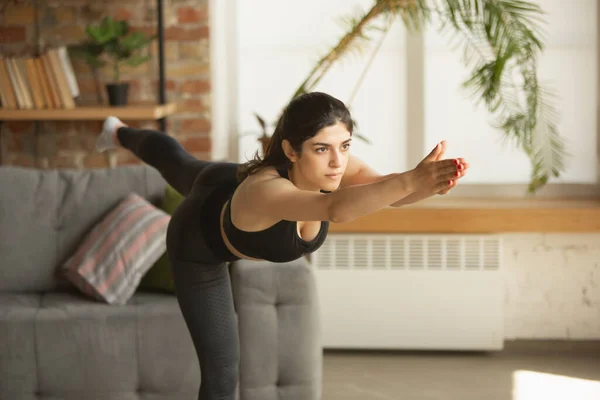 Deportiva joven musulmana que toma clases de yoga en línea y practica en casa — Foto de Stock