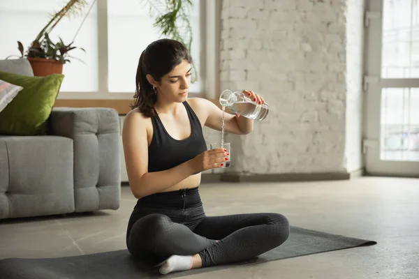 Sportieve jonge moslim vrouw die online yoga lessen neemt en thuis oefent — Stockfoto