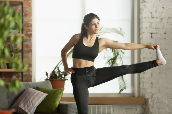 Deportiva joven musulmana que toma clases de yoga en línea y practica en casa — Foto de Stock