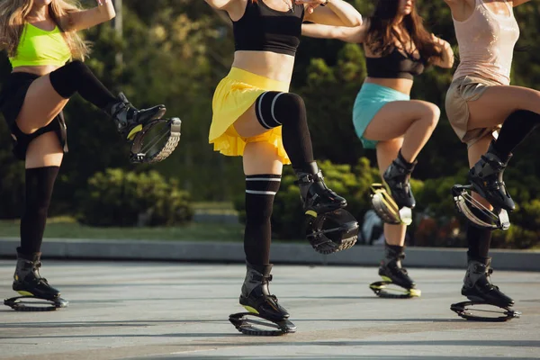 Schöne Frauen in Sportbekleidung springen in einem Kangoo springt Schuhe auf der Straße an einem sonnigen Sommertag — Stockfoto