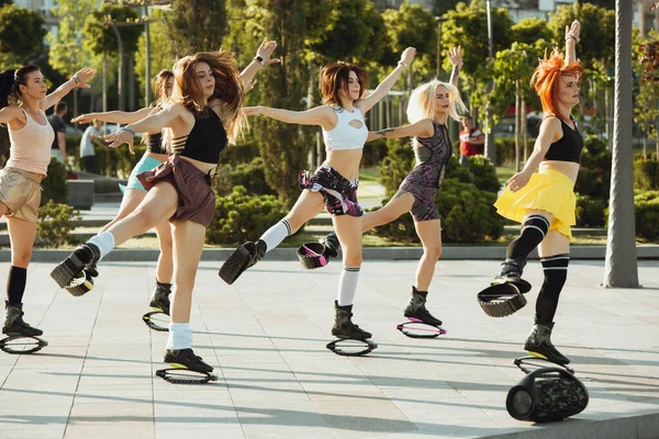 Schöne Frauen in Sportbekleidung springen in einem Kangoo springt Schuhe auf der Straße an einem sonnigen Sommertag — Stockfoto