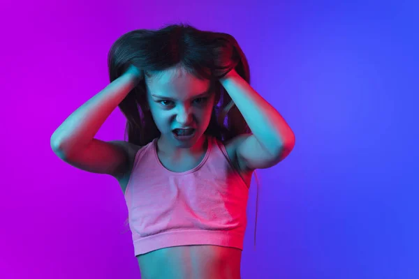 Pequenas meninas caucasianas retrato isolado no gradiente rosa-azul fundo em luz de néon . — Fotografia de Stock