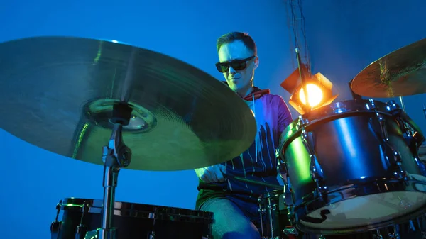 Jovem músico caucasiano tocando em fundo gradiente em luz de néon. Conceito de música, hobby, festival — Fotografia de Stock