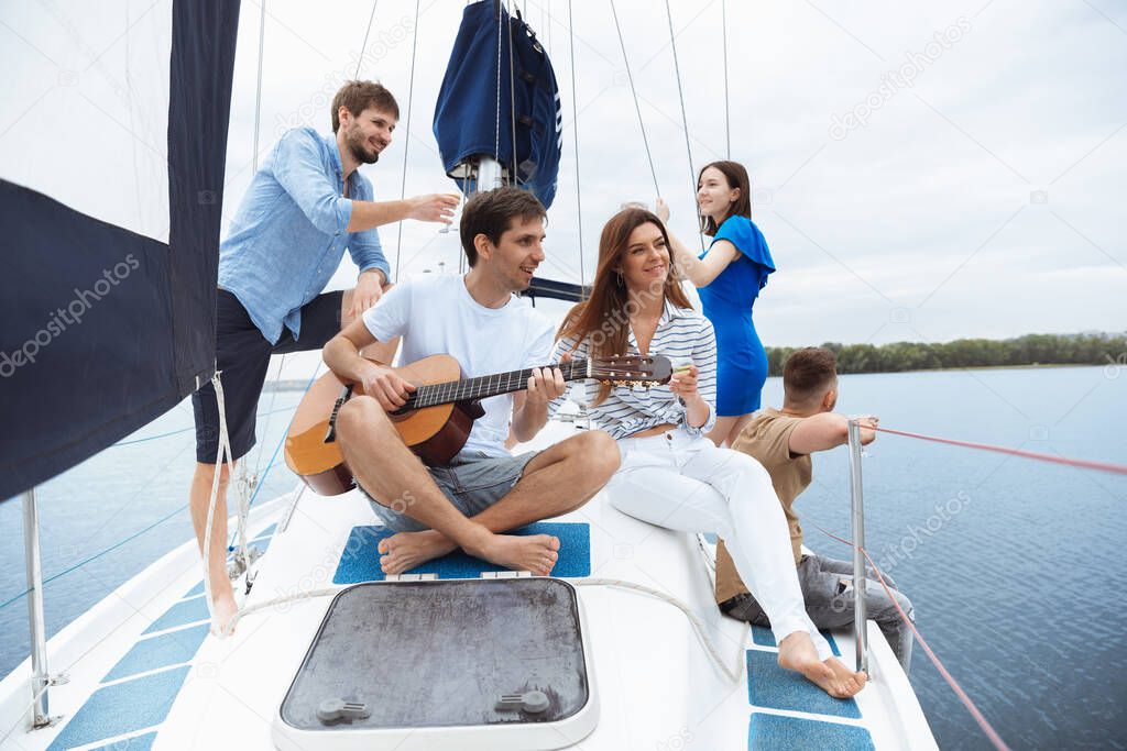 Group of happy friends drinking vodka cocktails at boat party outdoor, cheerful and happy