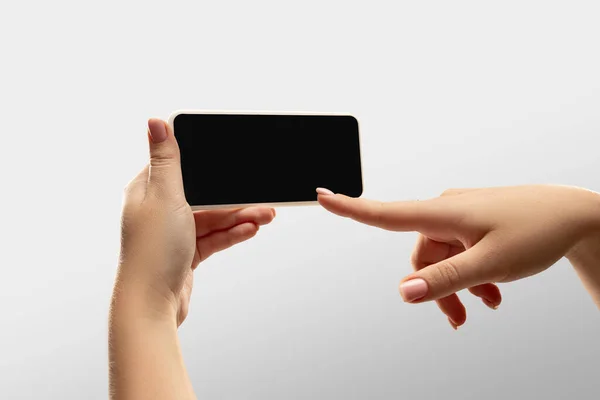 人気のスポーツマッチや世界中の選手権をオンラインで見ている間に空白の画面でスマートフォンを保持している女性の手を閉じます。広告のコピースペース — ストック写真