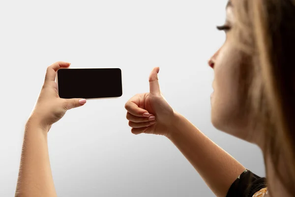 Nahaufnahme weiblicher Hände, die ihr Smartphone mit leerem Bildschirm halten, während sie online populäre Sportspiele und Meisterschaften auf der ganzen Welt verfolgen. Copyspace für Werbung — Stockfoto