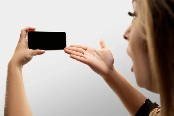 Крупним планом жіночі руки тримають смартфон з порожнім екраном під час онлайн-перегляду популярних спортивних матчів та чемпіонатів по всьому світу. Копія простору для реклами — стокове фото