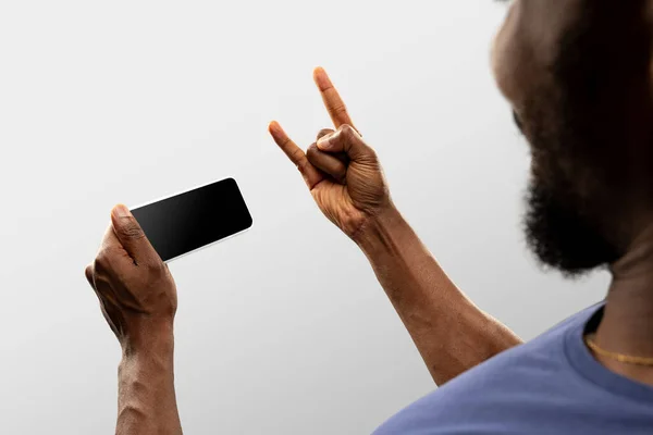 Primer plano manos masculinas sosteniendo teléfono inteligente con pantalla en blanco durante la observación en línea de partidos deportivos populares y campeonatos en todo el mundo. Copyspace para anuncio —  Fotos de Stock