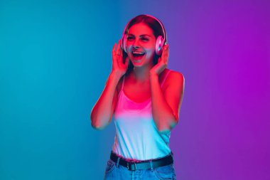 Caucasian young womans portrait isolated on gradient purple-blue background in neon light clipart