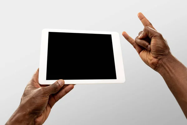 Feche as mãos masculinas segurando tablet com tela em branco durante a observação on-line de jogos esportivos populares e campeonatos em todo o mundo. Copyspace para anúncio — Fotografia de Stock
