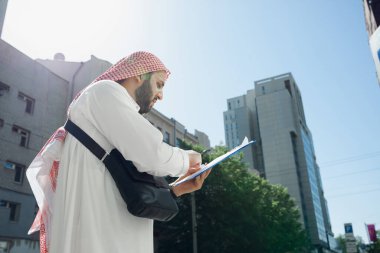 Gülümseyen zengin Arap adamlar şehirde emlak satın alıyorlar.