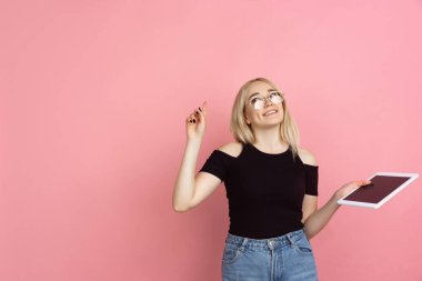 Portrait of young caucasian woman with bright emotions on coral pink studio background clipart