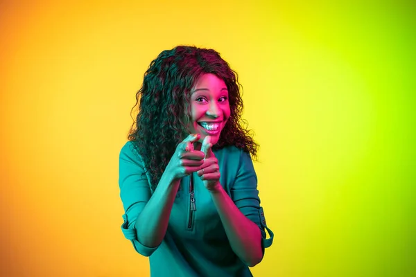 Afro-Amerikaanse jonge vrouwen portret geïsoleerd op gradiënt geel-groene achtergrond in neon licht — Stockfoto