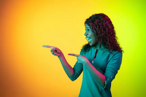 Retrato de mulheres jovens afro-americanas isolado no gradiente amarelo-verde fundo em luz de néon — Fotografia de Stock