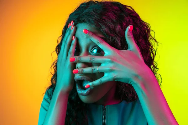 African-american young womans portrait isolated on gradient yellow-green background in neon light — Stock Photo, Image