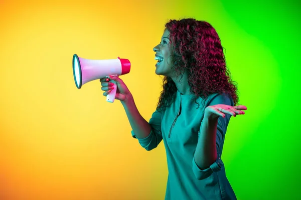 African-american young womans portrait isolated on gradient yellow-green background in neon light — Stock Photo, Image