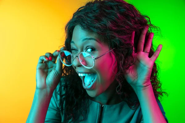 Afro-Amerikaanse jonge vrouwen portret geïsoleerd op gradiënt geel-groene achtergrond in neon licht — Stockfoto