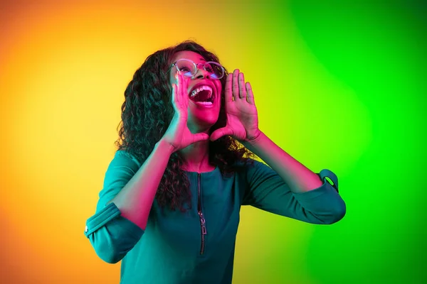 Africko-americké mladé ženy portrét izolovaný na gradient žlutozelené pozadí v neonovém světle — Stock fotografie