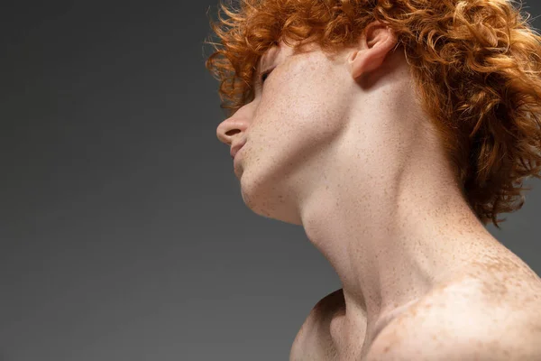 Portrait of beautiful redhead man isolated on grey studio background. Concept of beauty, skin care, fashion and style