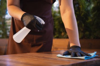 Garson, bir restoranda maske takıyor. Coronavirüs salgını sırasında eldiven takıyor.