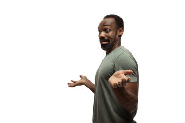 Beyaz stüdyo arka planında izole edilmiş komik, alışılmadık popüler duyguları ve jestleri olan genç Afro-Amerikan bir adam.