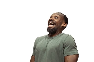 Beyaz stüdyo arka planında izole edilmiş komik, alışılmadık popüler duyguları ve jestleri olan genç Afro-Amerikan bir adam.