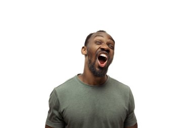 Beyaz stüdyo arka planında izole edilmiş komik, alışılmadık popüler duyguları ve jestleri olan genç Afro-Amerikan bir adam.