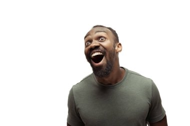 Beyaz stüdyo arka planında izole edilmiş komik, alışılmadık popüler duyguları ve jestleri olan genç Afro-Amerikan bir adam.