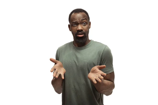 Jonge Afrikaans-Amerikaanse man met grappige, ongewone populaire emoties en gebaren geïsoleerd op witte studio achtergrond — Stockfoto