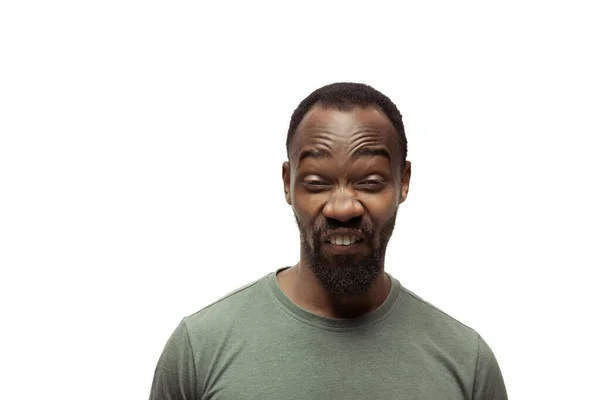 Jeune homme afro-américain avec des émotions populaires drôles et insolites et des gestes isolés sur fond de studio blanc — Photo