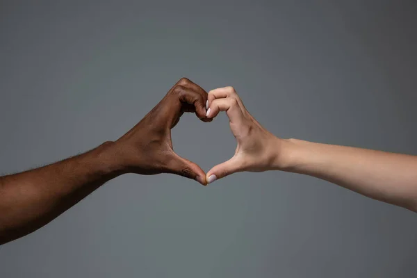 Tolerancja rasowa. Szanuj jedność społeczną. Afrykańskie i kaukaskie ręce gestykulujące izolowane na szarym tle studia — Zdjęcie stockowe